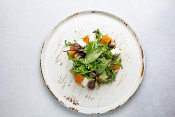 Delicious salad with feta cheese, arugula and pumpkin