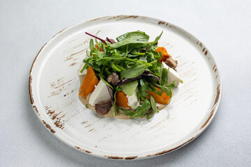 Delicious salad with feta cheese, arugula and pumpkin