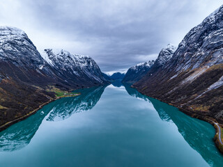symmetrical erial view over blue mountain lake in norwegian mountains with reflections - obrazy, fototapety, plakaty