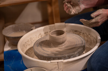 Potters wheel with hands forming clay to art