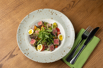Delicious salad with tuna, egg, tomato and arugula