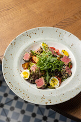 Delicious salad with tuna, egg, tomato and arugula