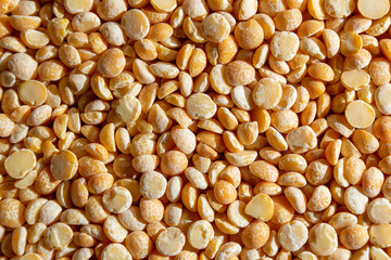 Uncooked Polished Split Peas Background. A Culinary Canvas of Dry Yellow Peas, Creating a Lively and Textured Background for Gourmet Cooking. Scattered Raw Polished Peas. Healthy Eating Ingredients