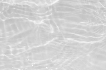 White water with ripples on the surface. Defocus blurred transparent white colored clear calm water surface texture with splashes and bubbles. Water waves with shining pattern texture background.