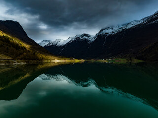 scenic norwegian landscape with mountains, cabin on shore of the cyan Oldevatn lake with reflections
