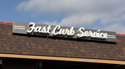 Fast Curb Service sign at a drive in restaurant. After COVID 19, restaurants began offering delivery and pickup service.