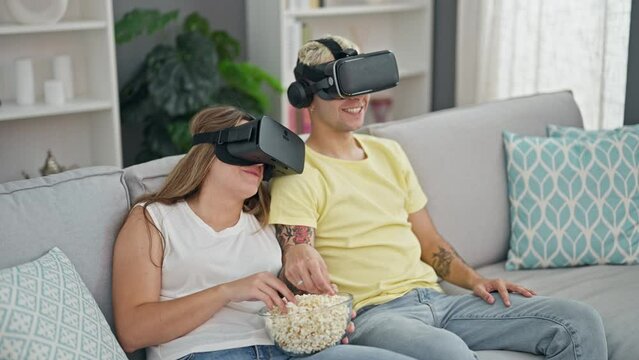 Beautiful couple watching movie on virtual reality glasses at home