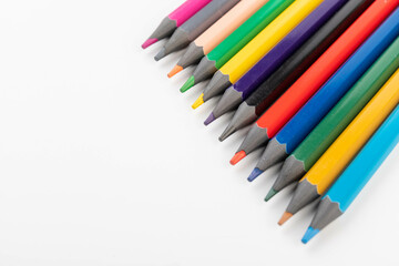 Wooden color pencils arranged in row on white isolated background. Selective focus