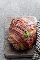 Italian bacon wrapped meatloaf on wooden board