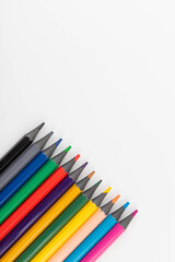 Wooden color pencils arranged in row on white isolated background. Selective focus