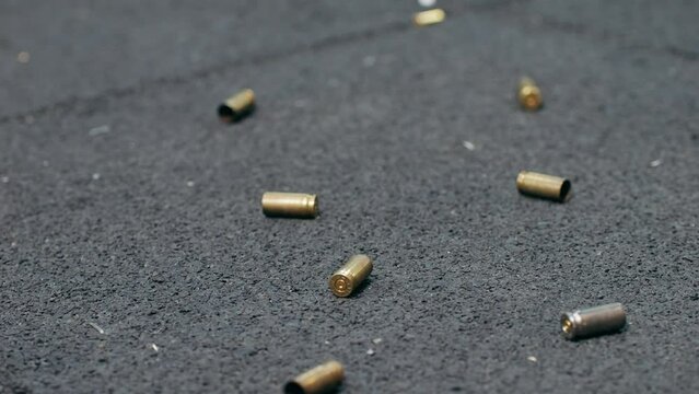 Empty bullets fall on the floor on shooting range. Sport shooter police training.