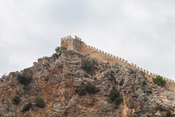 Fototapeta na wymiar Medieval fortress in the city of Alanya in southern Turkey. Fortress on a rocky peninsula in the Mediterranean Sea.