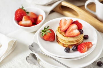 Mini pancakes with fresh strawberries for breakfast