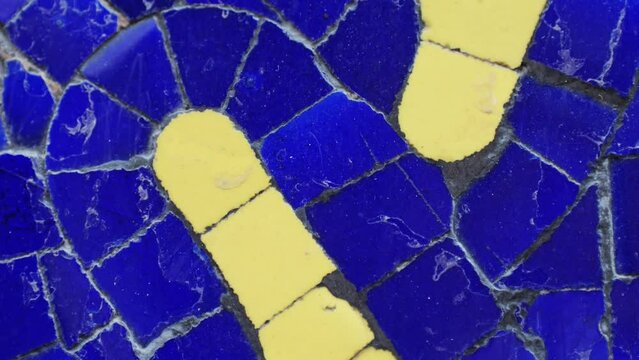 Closeup of mosaic of colored ceramic tile by Antoni Gaudi at his Parc Guell, Barcelona, Spain
