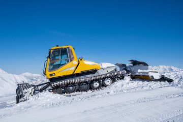 Snow removal equipment. Snowcat in the mountains against the blue sky.