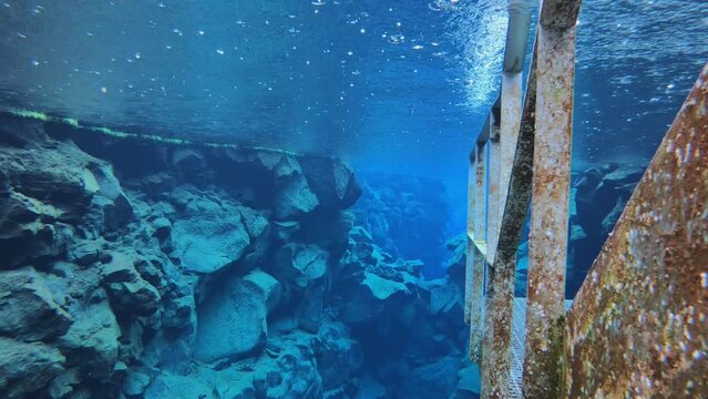 SLOW MOTION SHOT - Silfra is a fissure between the North American and Eurasian tectonic plates with over 100m visibility underwater in Thingvellir National Park, Iceland.