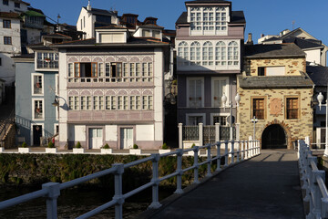 Fototapeta na wymiar Kiss bridge in Luarca with typical house facades in a sunny day, Asturias, Spain.