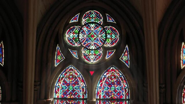 Luminous saints in stained glass, draped in curtains.
