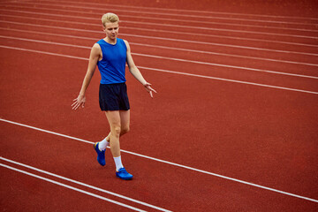 Obraz premium Serene moment as a jogger readies for the sprint. Young athlete man, professional sportsman warming-up before championship.