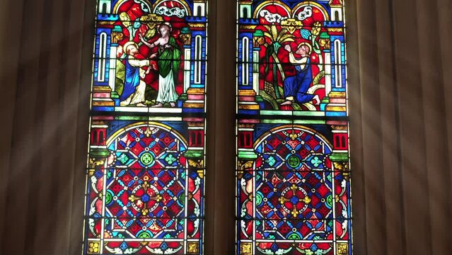 Richly colored glass window with angelic figures.