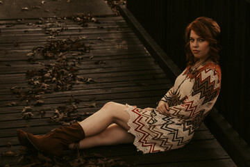 Obraz na płótnie Canvas Woman sitting on a wooden bridge