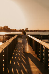Girl standing on dock at sunset