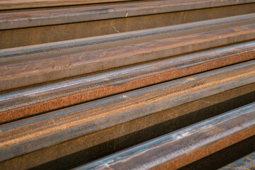 Many new rails of different length stored at a ground for old rails replacement. Diagonal placement close up photo