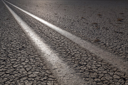 Tire tracks on a dry and cracked desert floor in Namib-Naukluft Park; Sossusvlei, Namibia