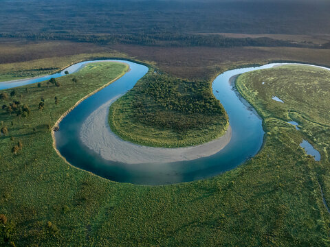 Aerial view of a river bend in Mount Aspiring National Park at sunrise; Haast, South Island, New Zealand