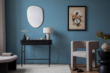 Cozy living room interior with mock up poster frame, gray armchair, blue wall, black console, stylish lamp, vase with flowers, wooden stand, bench and personal accessories. Home decor. Template.