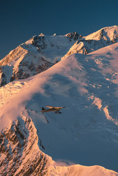 Ski plane flies past Mount Denali in Denali National Park and Preserve; Alaska, United States of America