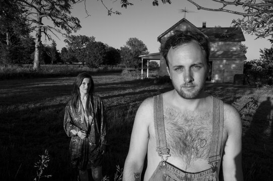 Man and woman stand outside an old house; Bennet, Nebraska, United States of America