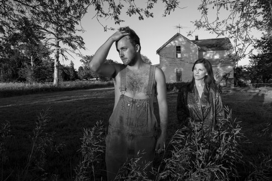 Man and woman stand outside an old house; Bennet, Nebraska, United States of America