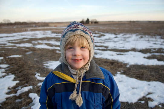 Young boy keeps warm in a cold Nebraska winter, USA; Cortland, Nebraska, United States of America