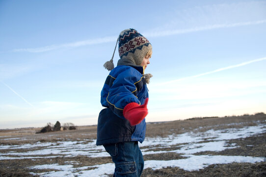 Young boy keeps warm in a cold Nebraska winter, USA; Cortland, Nebraska, United States of America