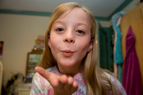 Girl in her bedroom getting ready for bed and blows a kiss to the camera to say goodnight; Lincoln, Nebraska, United States of America