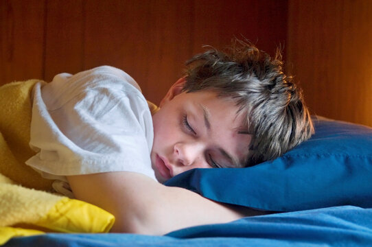 Teenage boy asleep in his bed; Halsey, Nebraska, United States of America