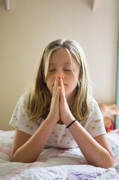 Preteen girl prays in her bedroom; Lincoln, Nebraska, United States of America