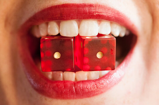 Woman holds two dice between her lips; Lincoln, Nebraska, United States of America