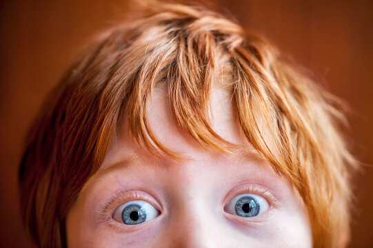 Close up of a young redhead with wide-eyed blue eyes; Studio