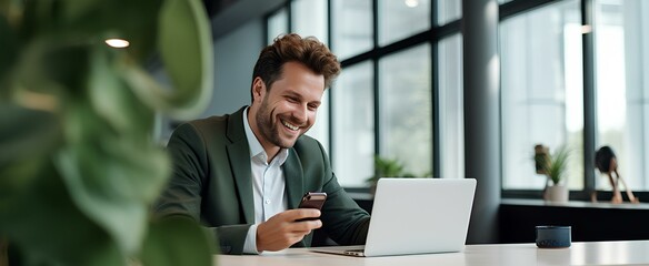 Happy business man holding phone using cellphone in office. Smiling professional businessman...