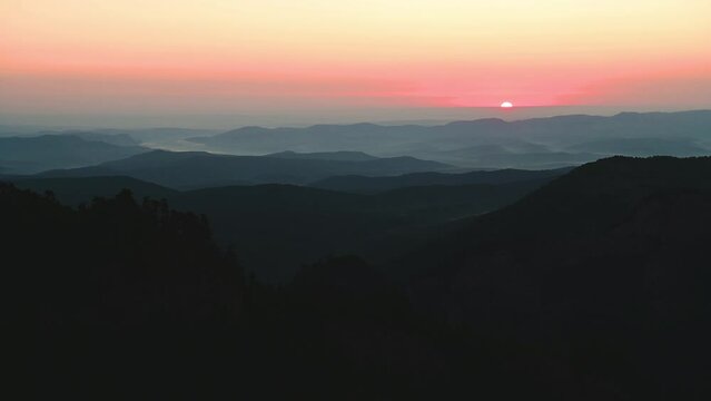 timelapse, the sun comes over the horizon in the mountains