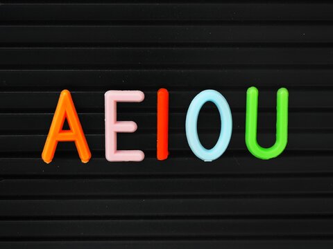 Colorful Aeiou uppercase vowels on a letter board