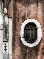 View of oval window on the wall in Venice.  Selective focus