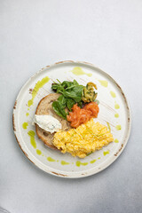 Delicious breakfast - Scrambled eggs with cheese, toast and salmon