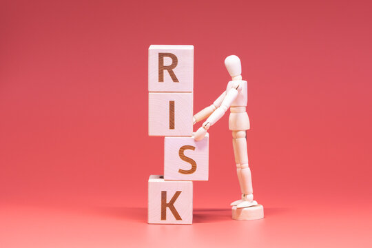 Manikin stopping the wooden cubes from falling. Risk management concept.