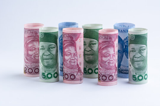 The new Nigerian currency, money the Naira notes, rolled and standing on a white background