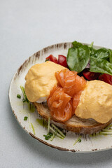 Delicious breakfast - Eggs Benedict with salmon and tomato