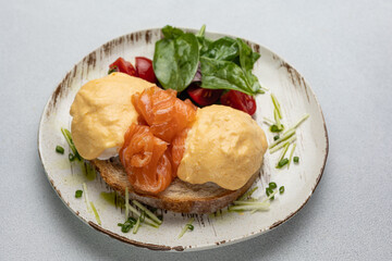 Delicious breakfast - Eggs Benedict with salmon and tomato