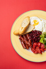 Delicious breakfast - Eggs with sausages, beans, and tomatoes